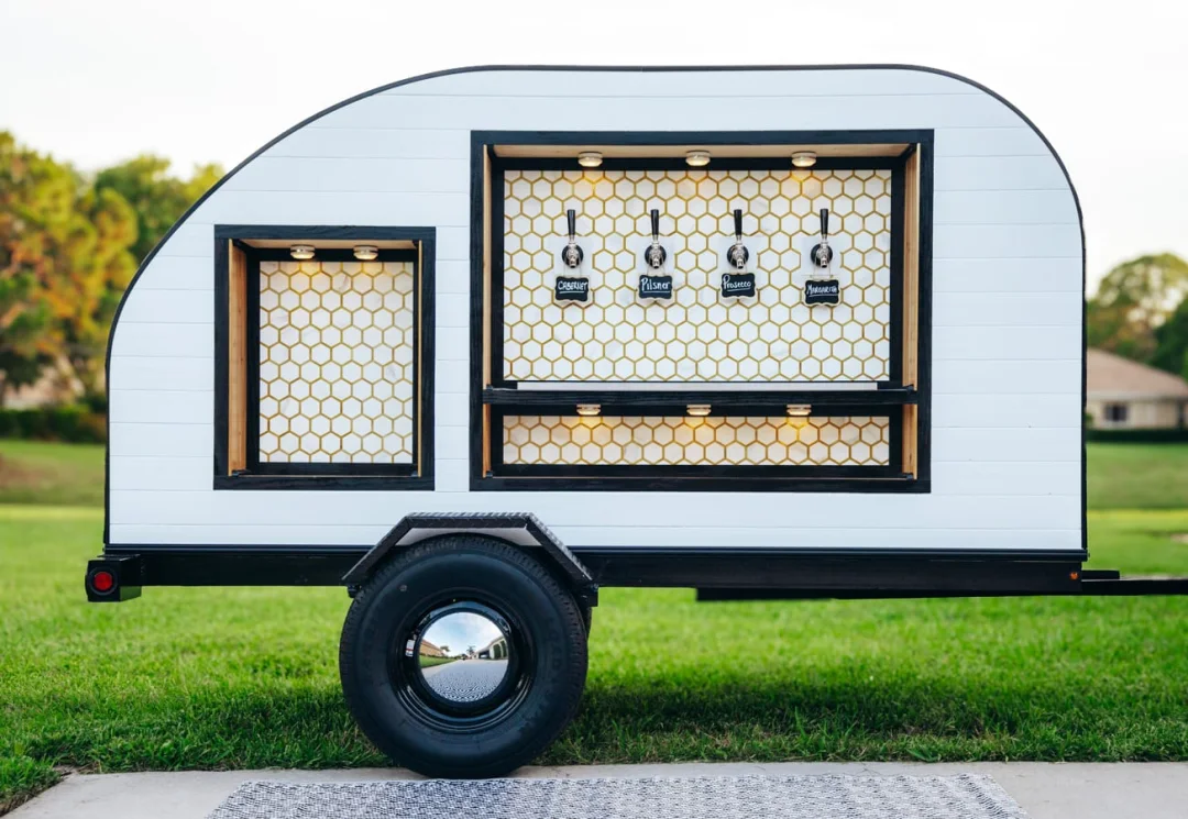 White teardrop bar trailer on green lawn